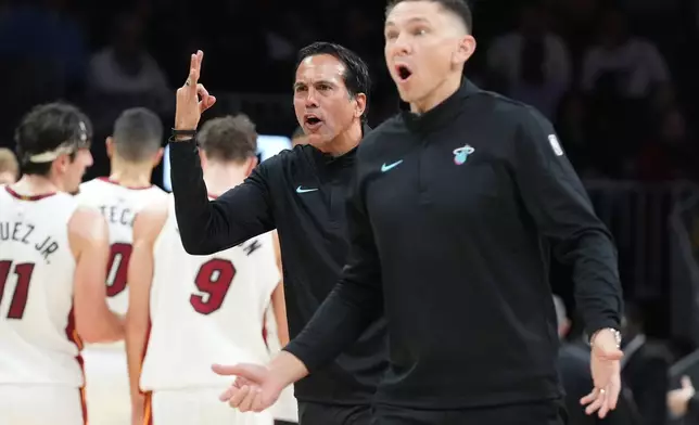 Miami Heat head coach Erik Spoelstra, center and assistant head coach Chris Quinn react to a call during the first half of an NBA basketball game against the Atlanta Hawks Tuesday, Feb. 3, 2026, in Miami. (AP Photo/Marta Lavandier)