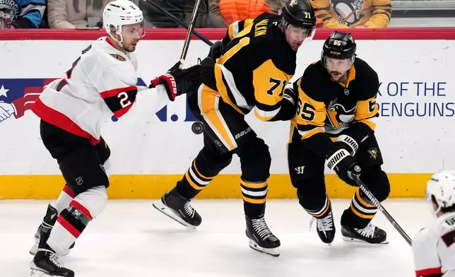 Ottawa Senators' Artem Zub (2) is defended by Pittsburgh Penguins' Evgeni Malkin (71) and Erik Karlsson (65) during the first period of an NHL hockey game in Pittsburgh, Monday, Feb. 2, 2026. (AP Photo/Gene J. Puskar)