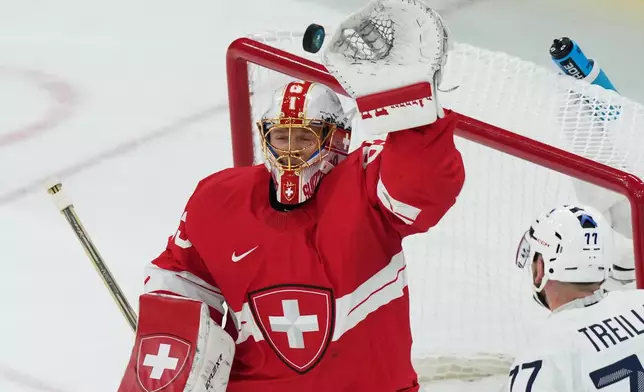 Switzerland's goalkeeper Leonardo Genoni , makes a save during a preliminary round match of men's ice hockey between Switzerland and France at the 2026 Winter Olympics, in Milan, Italy, Thursday, Feb. 12, 2026. (AP Photo/Carolyn Kaster)