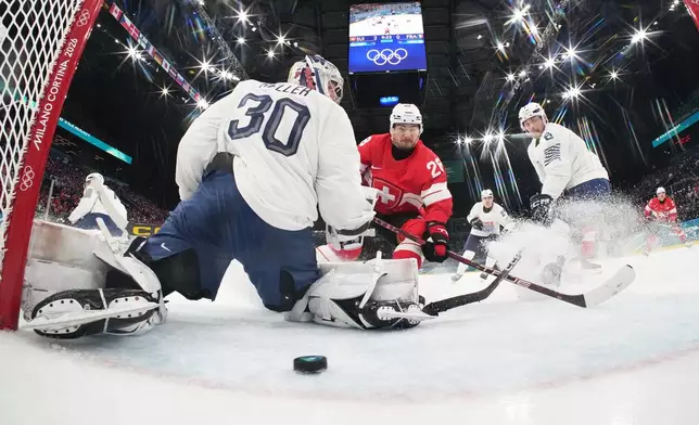 Switzerland's Timo Meier, center, scores his sides third goal past France's goalkeeper Antoine Keller during a preliminary round match of men's ice hockey between Switzerland and France at the 2026 Winter Olympics, in Milan, Italy, Thursday, Feb. 12, 2026. (Mike Segar/Pool Photo via AP)