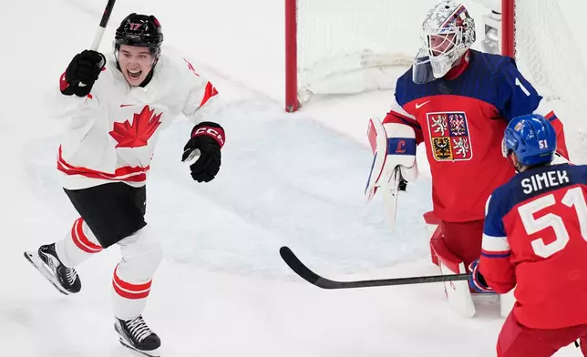during a preliminary round match of men's ice Canada's Macklin Celebrini celebrates after scoring his sides first goal past Czechia's goalkeeper Lukas Dostal hockey between Czech Republic and Canada at the 2026 Winter Olympics, in Milan, Italy, Thursday, Feb. 12, 2026. (AP Photo/Petr David Josek)