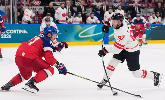 Czechia's Radim Simek tries to block a shot by Canada's Connor McDavid during a preliminary round match of men's ice hockey between Czech Republic and Canada at the 2026 Winter Olympics, in Milan, Italy, Thursday, Feb. 12, 2026. (AP Photo/Petr David Josek)