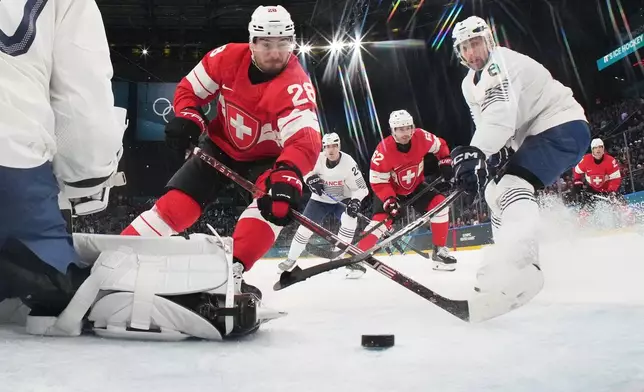Switzerland's Timo Meier, center, scores his sides third goal past France's goalkeeper Antoine Keller during a preliminary round match of men's ice hockey between Switzerland and France at the 2026 Winter Olympics, in Milan, Italy, Thursday, Feb. 12, 2026. (Mike Segar/Pool Photo via AP)