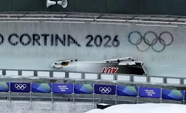 Austria's team Jakob Mandlbauer, Daniel Bertschler, Sebastian Mitterer and Daiyehan Nichols-Bardi crashes during a four man bobsled run at the 2026 Winter Olympics, in Cortina d'Ampezzo, Italy, Saturday, Feb. 21, 2026. (AP Photo/Aijaz Rahi)