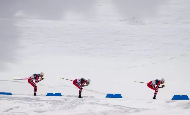 Emil Iversen, of Norway, from right, Martin Loewstroem Nyenget, of Norway, and Johannes Hoesflot Klaebo, of Norway, compete in the cross country skiing men's 50km mass start Classic at the 2026 Winter Olympics, in Tesero, Italy, Saturday, Feb. 21, 2026. (AP Photo/Evgeniy Maloletka)
