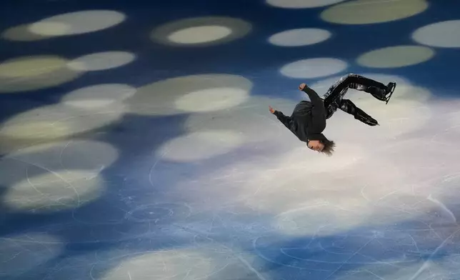 Ilia Malinin of the United States does a back flip during his performance in the figure skating exhibition at the 2026 Winter Olympics, in Milan, Italy, Saturday, Feb. 21, 2026. (AP Photo/Francisco Seco)
