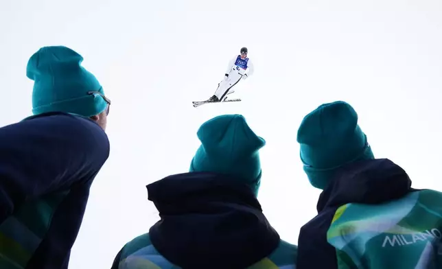 Workers watch as United States' Kaila Kuhn (5-1) practices before the freestyle skiing mixed team aerials final at the 2026 Winter Olympics, in Livigno, Italy, Saturday, Feb. 21, 2026. (AP Photo/Gregory Bull)