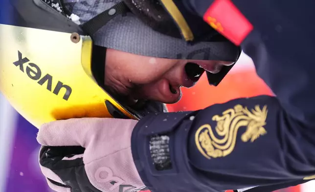 China's Li Tianma (1-3) reacts after crashing during the freestyle skiing mixed team aerials final at the 2026 Winter Olympics, in Livigno, Italy, Saturday, Feb. 21, 2026. (AP Photo/Lindsey Wasson)