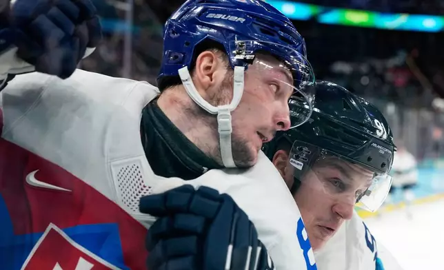 Slovakia's Oliver Okuliar (8) challenges with Finland's Oliver Kapanen (91) during a men's ice hockey bronze medal game between Slovakia and Finland at the 2026 Winter Olympics, in Milan, Italy, Saturday, Feb. 21, 2026. (AP Photo/Hassan Ammar)