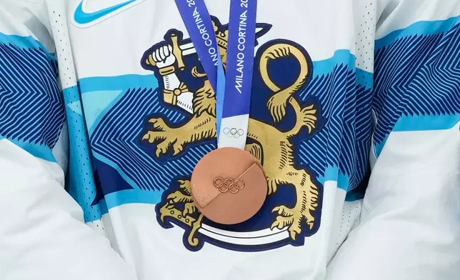 Finland's Artturi Lehkonen is decorated with bronze medal during victory ceremony after a men's ice hockey bronze medal game between Slovakia and Finland at the 2026 Winter Olympics, in Milan, Italy, Saturday, Feb. 21, 2026. (AP Photo/Hassan Ammar)