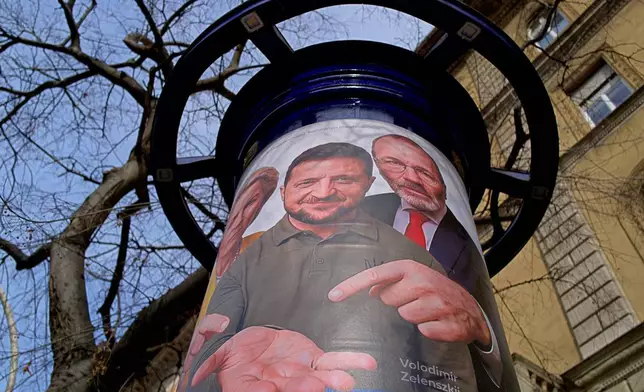 A billboard shows an AI-generated image of Ukrainian President Volodymyr Zelenskyy, center, flanked by European officials, in Budapest, Hungary, Monday, Feb. 23, 2026. (AP Photo/Bela Szandelszky)
