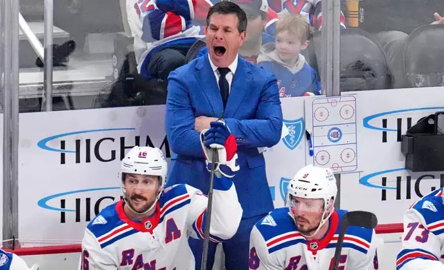 New York Rangers head coach Mike Sullivan, center top, yells instructions during the first period of an NHL hockey game against the Pittsburgh Penguins in Pittsburgh, Saturday, Jan. 31, 2026. (AP Photo/Gene J. Puskar)