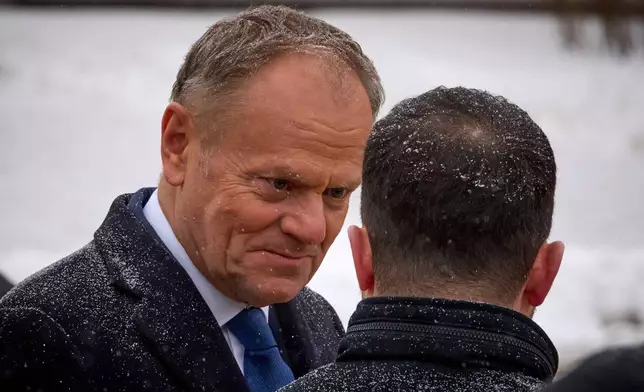 Poland's Prime Minister Donald Tusk, left, talks with Ukrainian President Volodymyr Zelenskyy after a commemorative ceremony at the Memorial Wall of Fallen Defenders of Ukraine in Kyiv, Ukraine, Thursday, Feb. 5, 2026. (AP Photo/Efrem Lukatsky)