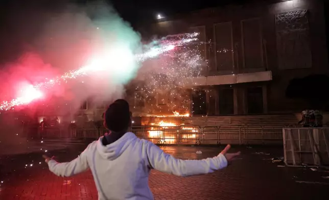 Protesters throw Molotov cocktails, flares and fireworks during an anti-government rally outside Prime Minister's office over corruption scandals and broader political issues, in Tirana, Albania, Tuesday, Feb. 10, 2026. (AP Photo/Hameraldi Agolli)