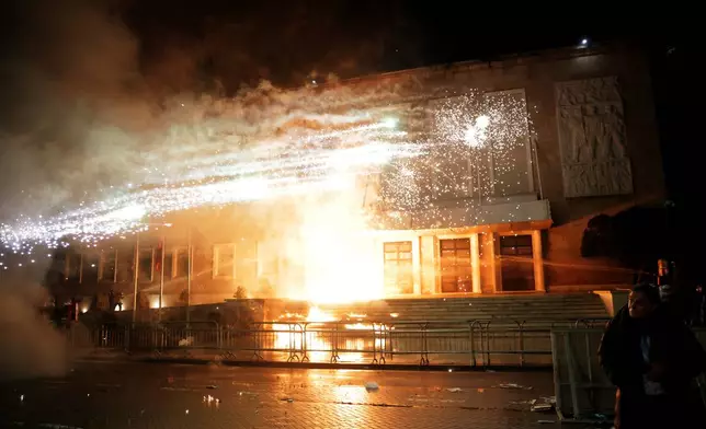 Protesters throw Molotov cocktails, flares and fireworks during an anti-government rally outside Prime Minister's office over corruption scandals and broader political issues, in Tirana, Albania, Tuesday, Feb. 10, 2026. (AP Photo/Hameraldi Agolli)