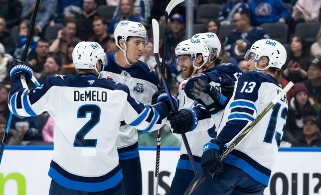 Winnipeg Jets' Kyle Connor, center, celebrates his goal against the Vancouver Canucks with Dylan DeMelo (2), Logan Stanley (64), Mark Scheifele (55), and Gabriel Vilardi (13) during the first period of an NHL hockey game in Vancouver, B.C., on Wednesday, Feb. 25, 2026. (Ethan Cairns/The Canadian Press via AP)