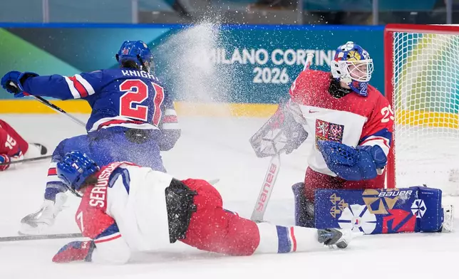 Czechia's Klara Seroiszkova slides into Czechia's Klara Peslarova, right, as United States' Hilary Knight scores her sides fourth goal during a preliminary round match of women's ice hockey between United States and Czechia at the 2026 Winter Olympics, in Milan, Italy, Thursday, Feb. 5, 2026. (AP Photo/Petr David Josek)