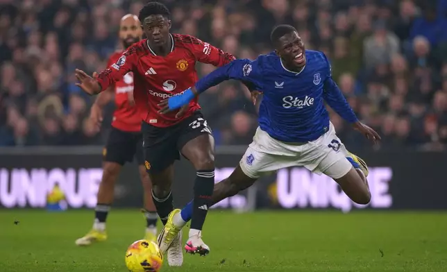 Manchester United's Kobbie Mainoo tackles Everton's Thierno Barry during the Premier League soccer match between Manchester United and Everton in Liverpool, England, Monday, Feb. 23, 2026. (AP Photo/Ian Hodgson)