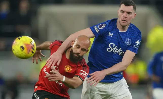 Manchester United's Bryan Mbeumo, left, and Everton's Michael Keane fight for the ball during the Premier League soccer match between Manchester United and Everton in Liverpool, England, Monday, Feb. 23, 2026. (AP Photo/Ian Hodgson)