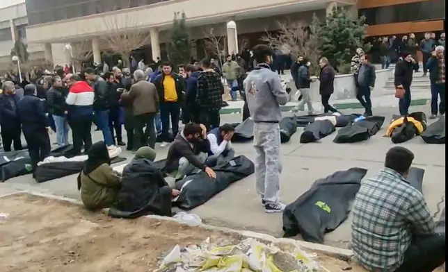 FILE - This image from video taken between Jan. 9 and Jan. 11, 2026, and verified by AP, shows bodies and mourners outside a morgue in Iran, following a crackdown on protests in Kahrizak, Tehran province. (UGC via AP, File)