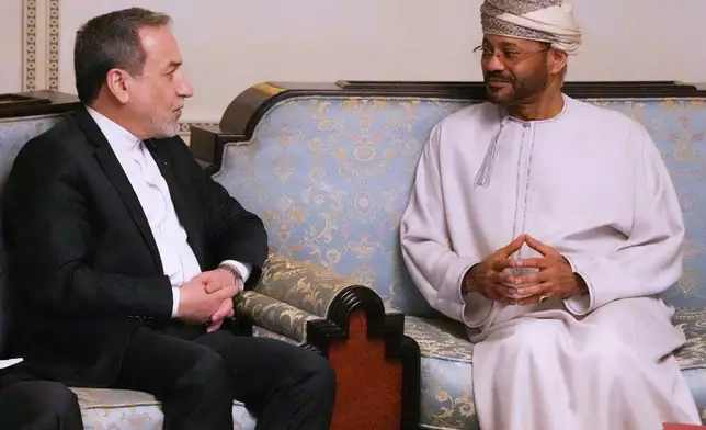 In this photo released by the Iranian Foreign Ministry, Iranian Foreign Minister Abbas Araghchi, left, speaks with his Omani counterpart Sayyid Badr Albusaidi during their meeting prior to Iran and the U.S. negotiations, in Muscat, Oman, Friday, Feb. 6, 2026. (Iranian Foreign Ministry via AP)