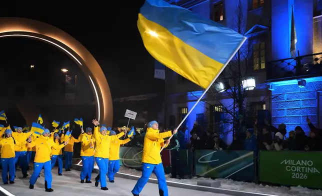 Vladyslav Heraskevych, flag bearer of Ukraine, leads his team in during the Olympic opening ceremony at the 2026 Winter Olympics, in Cortina d'Ampezzo, Italy, Friday, Feb. 6, 2026. (AP Photo/Misper Apawu)