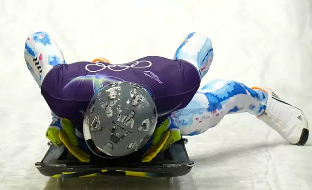 Ukraine's Vladyslav Heraskevych arrives at the finish during a men's skeleton training session at the 2026 Winter Olympics, in Cortina d'Ampezzo, Italy, Monday, Feb. 9, 2026. (AP Photo/Aijaz Rahi)
