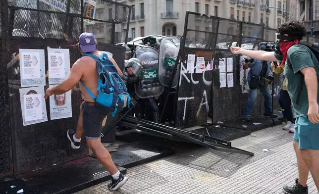 Protesters push against a police barrier during a march by trade unions and opposition groups against a labor reform bill proposed by President Javier Milei's government outside Congress in Buenos Aires, Argentina, Wednesday, Feb. 11, 2026. (AP Photo/Gustavo Garello)