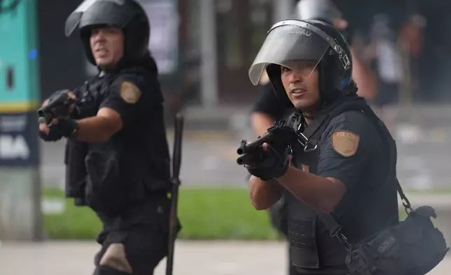 Police clash with protesters during a march by trade unions and opposition groups against a labor reform bill proposed by President Javier Milei's government in Buenos Aires, Argentina, Wednesday, Feb. 11, 2026. (AP Photo/Gustavo Garello)