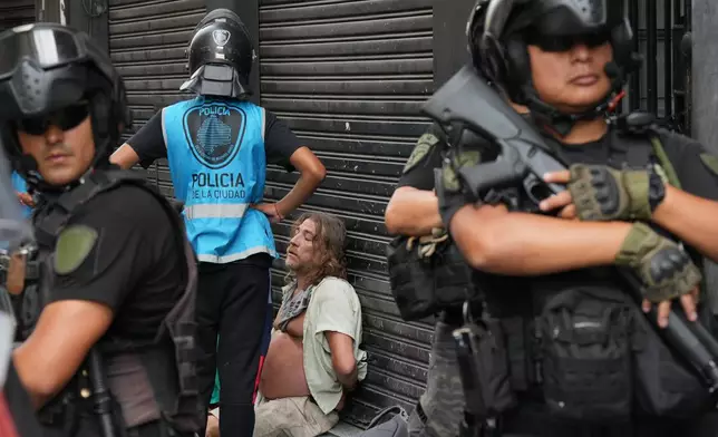 Police stand around a protester detained during a march by trade unions and opposition groups against a labor reform bill proposed by President Javier Milei's government in Buenos Aires, Argentina, Wednesday, Feb. 11, 2026.(AP Photo/Gustavo Garello)