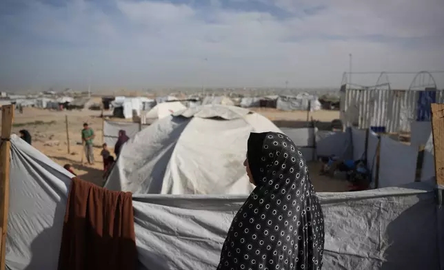 Siham Omran, 54, recently returned from Egypt after completing her medical treatment, looks at the tents of displaced people next to her that were set up in Khan Younis, southern Gaza Strip, Saturday, Feb. 7, 2026. (AP Photo/Abdel Kareem Hana)