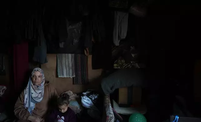 Rana al-Louh, 45, sits with her granddaughter, Sumaya Abu Suleiman, 3, inside the tent where they live, which had been erected in a schoolyard converted into a shelter in Nuseirat, in the central Gaza Strip, Saturday, Feb. 7, 2026. (AP Photo/Abdel Kareem Hana)
