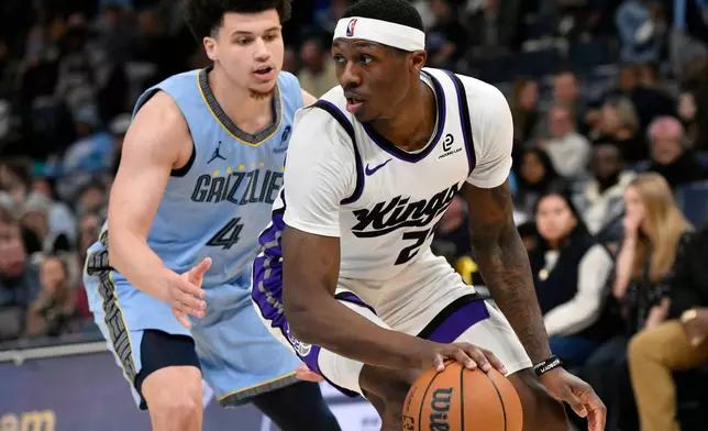 Sacramento Kings guard Daeqwon Plowden, right, handles the ball against Memphis Grizzlies guard Walter Clayton Jr. (4) in the first half of an NBA basketball game, Monday, Feb. 23, 2026, in Memphis, Tenn. (AP Photo/Brandon Dill)