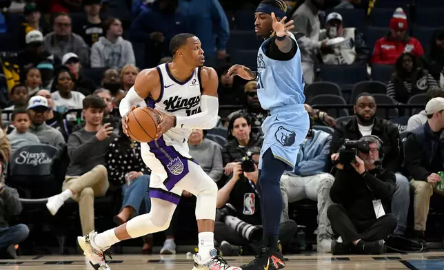 Sacramento Kings guard Russell Westbrook, left, handles the ball against Memphis Grizzlies guard Jahmai Mashack, right, in the first half of an NBA basketball game Monday, Feb. 23, 2026, in Memphis, Tenn. (AP Photo/Brandon Dill)