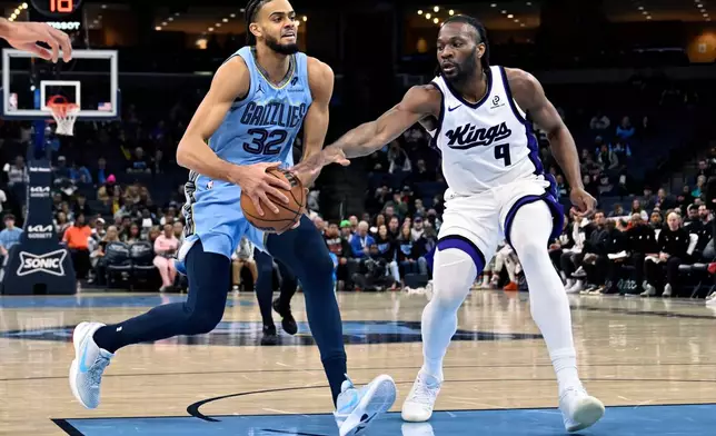 Memphis Grizzlies forward Ryan Rupert (32) drives against Sacramento Kings forward Precious Achiuwa (9) in the first half of an NBA basketball game Monday, Feb. 23, 2026, in Memphis, Tenn. (AP Photo/Brandon Dill)