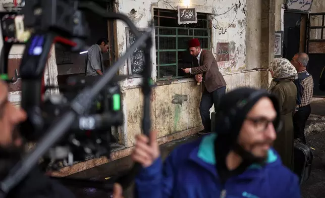 A television crew films an episode of the TV series "Al-Souriyoun al-Aada" ("The Syrian Enemies"), based on a novel of the same name that was banned under Bashar Assad, along a transformed street in central Aleppo, Syria, Friday, Feb. 13, 2026.(AP Photo/Ghaith Alsayed)