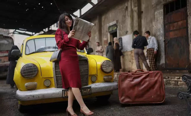 Rita Nasra, an extra in the series, poses for a photograph during the filming of an episode of the TV series "Al-Souriyoun al-Aada" ("The Syrian Enemies"), based on a novel of the same name that was banned under Bashar Assad, along a transformed street in central Aleppo, Syria, Friday, Feb. 13, 2026. (AP Photo/Ghaith Alsayed)