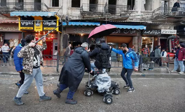A television crew films an episode of the TV series "Al-Souriyoun al-Aada" ("The Syrian Enemies"), based on a novel of the same name that was banned under Bashar Assad, along a transformed street in central Aleppo, Syria, Friday, Feb. 13, 2026. (AP Photo/Omar Sanadiki)