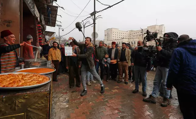 A television crew films an episode of the TV series "Al-Souriyoun al-Aada" ("The Syrian Enemies"), based on a novel of the same name that was banned under Bashar Assad, along a transformed street in central Aleppo, Syria, Friday, Feb. 13, 2026.(AP Photo/Omar Sanadiki)