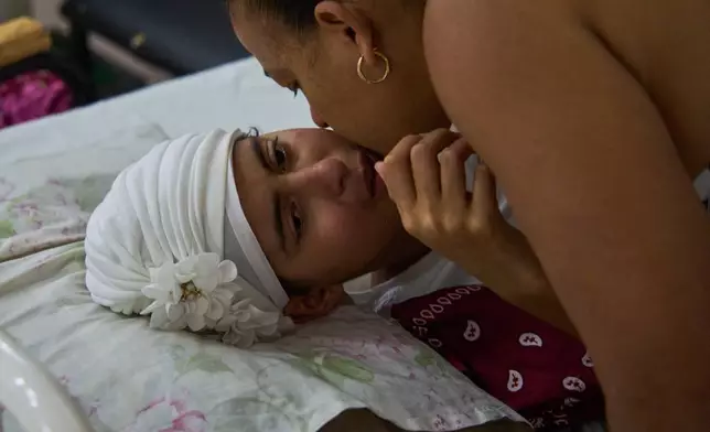 Niala Gonzalez, a cancer patient is kissed by her mother at the National Institute of Oncology and Radiology in Havana, Cuba, Friday, Feb. 20, 2026. (AP Photo/Ramon Espinosa)