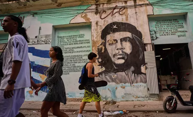 People walk past a mural of Che Guevara in Havana, Tuesday, Feb. 17, 2026. (AP Photo/Ramon Espinosa)