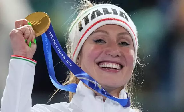 Francesca Lollobrigida of Italy celebrates with her gold medal on the podium of the women's 3,000 meters speedskating race at the 2026 Winter Olympics, in Milan, Italy, Saturday, Feb. 7, 2026. (AP Photo/Christophe Ena)