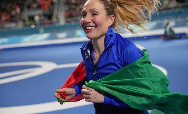 Gold medallist Francesca Lollobrigida of Italy celebrates with the Italian flag after the women's 3,000 meters speedskating race at the 2026 Winter Olympics, in Milan, Italy, Saturday, Feb. 7, 2026. (AP Photo/Christophe Ena)