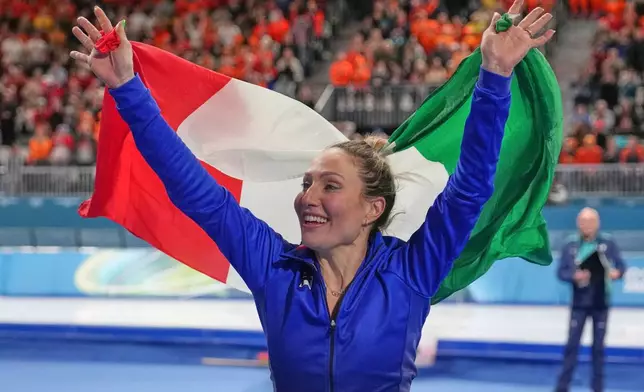 Gold medallist Francesca Lollobrigida of Italy celebrates with the Italian flag after the women's 3,000 meters speedskating race at the 2026 Winter Olympics, in Milan, Italy, Saturday, Feb. 7, 2026. (AP Photo/Christophe Ena)