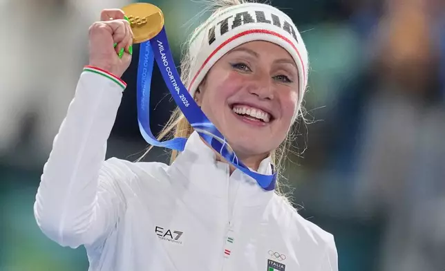Francesca Lollobrigida of Italy celebrates with her gold medal on the podium of the women's 3,000 meters speedskating race at the 2026 Winter Olympics, in Milan, Italy, Saturday, Feb. 7, 2026. (AP Photo/Christophe Ena)
