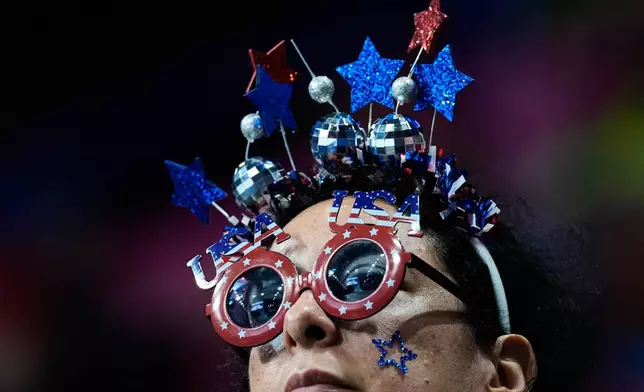 A fan waits for the short track speed skating men's 500m to start at the 2026 Winter Olympics, in Milan, Italy, Wednesday, Feb. 18, 2026. (AP Photo/Ashley Landis)