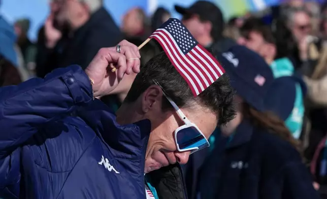 United States fans react following United States' Lindsey Vonn's crashed during an alpine ski women's downhill race, at the 2026 Winter Olympics, in Cortina d'Ampezzo, Italy, Sunday, Feb. 8, 2026. (AP Photo/Misper Apawu)