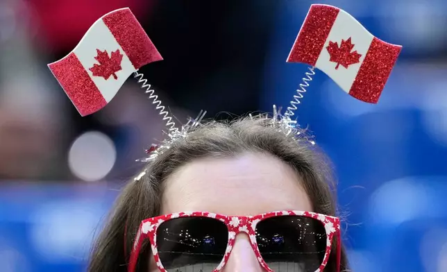 A Canadian fan watches as players warm up before a men's ice hockey qualification playoff game between Czechia and Denmark at the 2026 Winter Olympics, in Milan, Italy, Monday, Feb. 16, 2026. (AP Photo/Hassan Ammar)