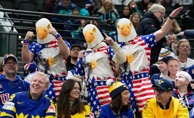 U.S fans wearing costumes strike a pose before a semifinal match of women's ice hockey between the United States and Sweden at the 2026 Winter Olympics, in Milan, Italy, Monday, Feb. 16, 2026. (AP Photo/Petr David Josek)