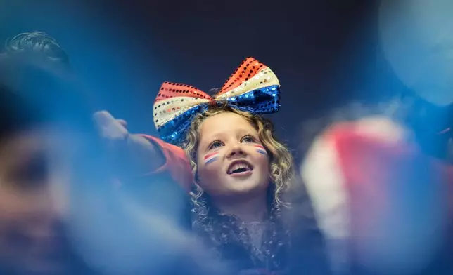 A fan cheers during the women's 1000 meter short track speed skating at the 2026 Winter Olympics, in Milan, Italy, Monday, Feb. 16, 2026. (AP Photo/Francisco Seco)
